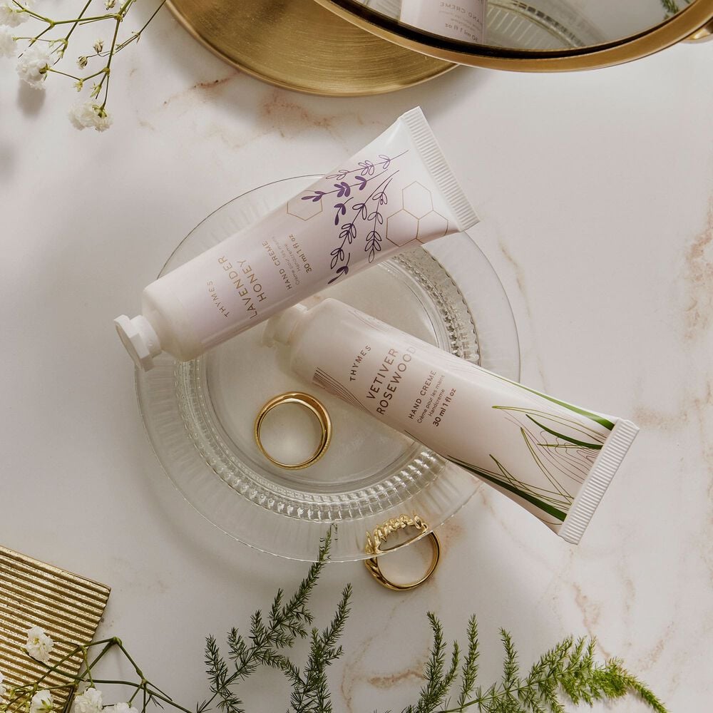 Thymes Vetiver Rosewood Hand Cream with Thymes Lavender Honey Hand Cream in clear dish image number 2
